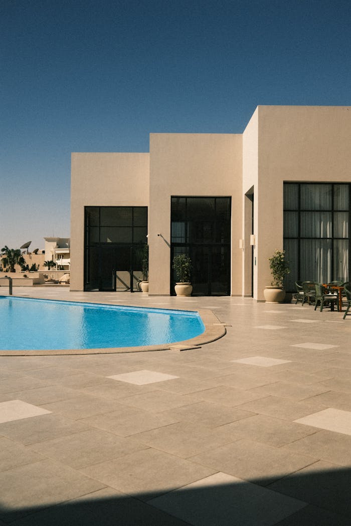 A contemporary villa featuring a luxurious swimming pool and sleek architectural design.