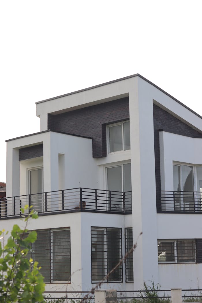 Sleek and modern white house featuring minimalist architectural design and large windows.