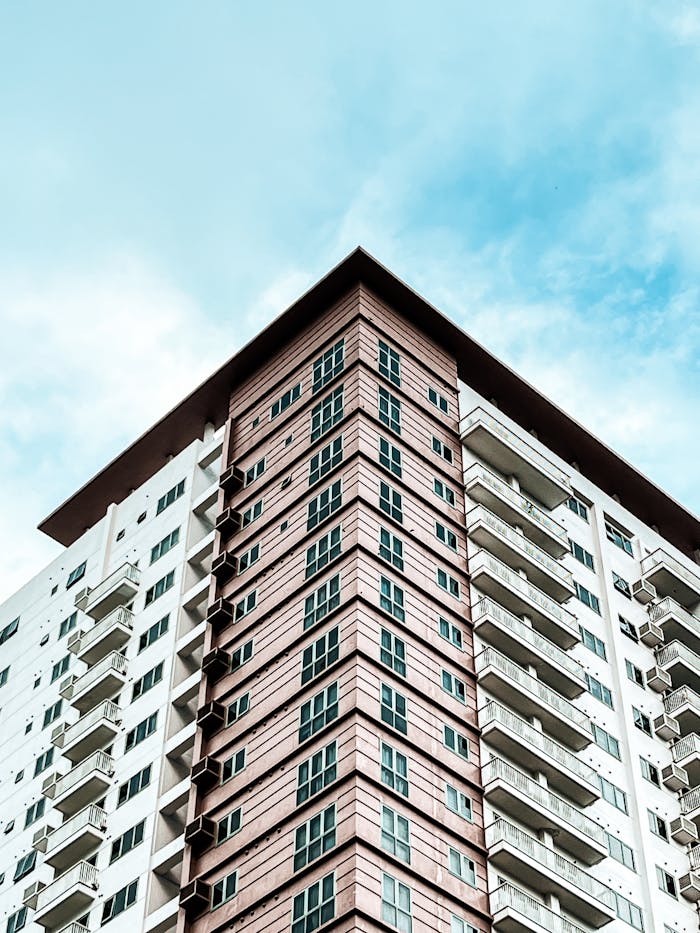 High angle view of a modern condominium building with a blue sky background.
