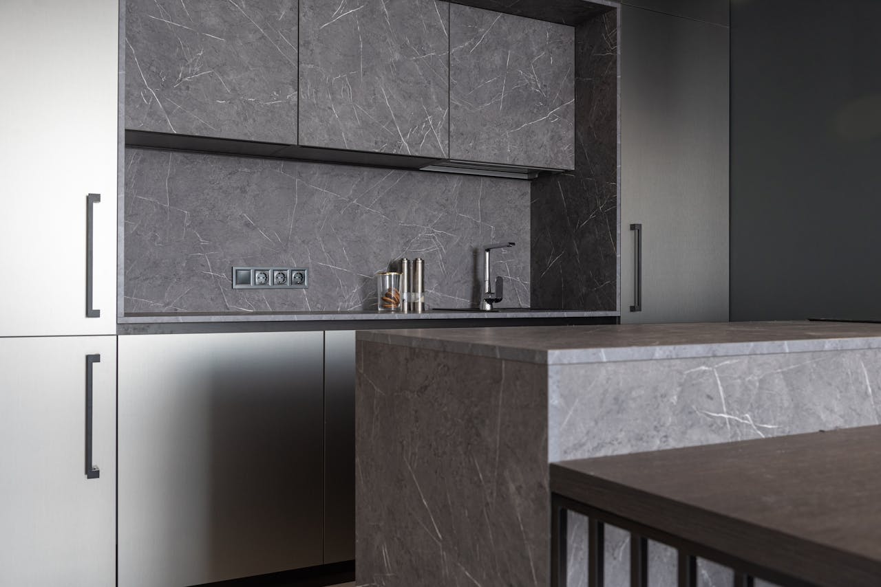 Sleek modern kitchen with gray marble surfaces and minimalist design.