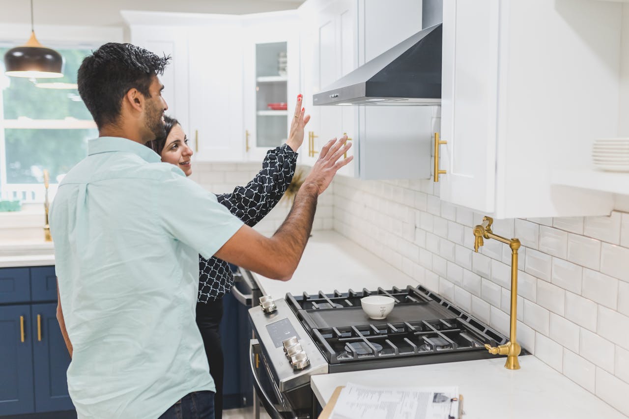 A real estate agent demonstrates kitchen features in a modern home. Ideal for real estate and lifestyle concepts.